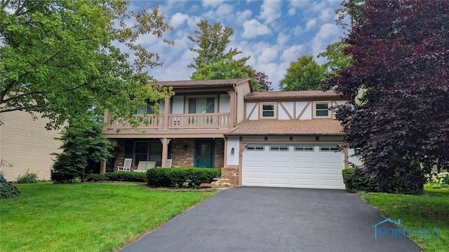 2359 Cheshire Woods Rd, Toledo, OH 43617 - view of front of house with a front lawn, asphalt driveway, a balcony, an attached garage, and brick siding