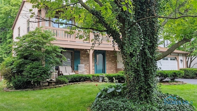 2359 Cheshire Woods Rd, Toledo, OH 43617 - obstructed view of property featuring a front lawn, a garage, brick siding, and a porch