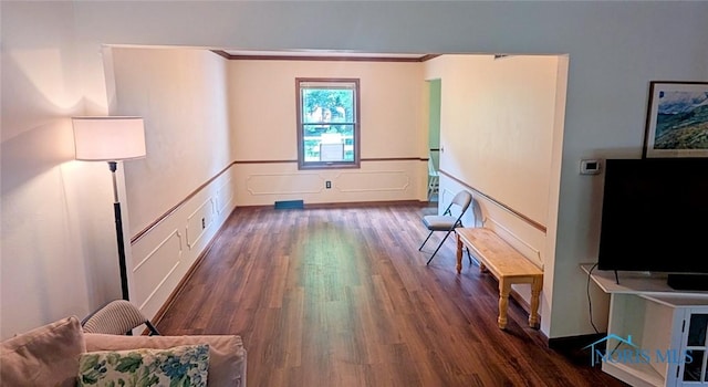 2359 Cheshire Woods Rd, Toledo, OH 43617 - living room featuring dark wood-style flooring, ornamental molding, a wainscoted wall, and a decorative wall