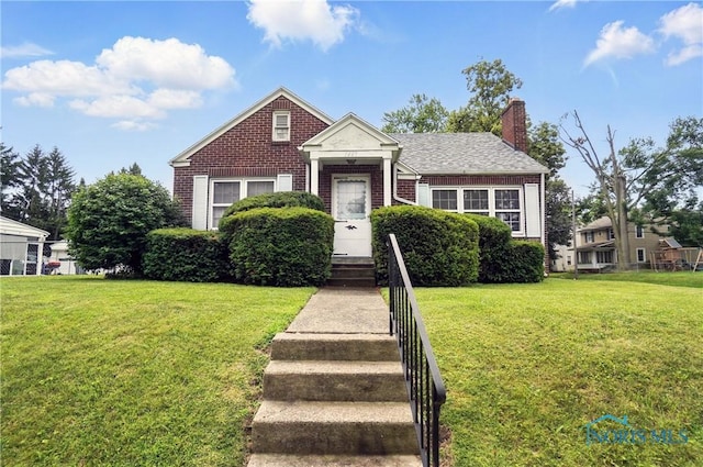 1447 Craigwood Rd, Toledo, OH 43612 - view of front of house with brick siding, a chimney, and a front yard