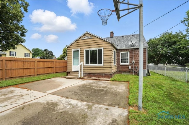 1447 Craigwood Rd, Toledo, OH 43612 - back of house featuring entry steps, a patio area, a fenced backyard, a chimney, and roof with shingles