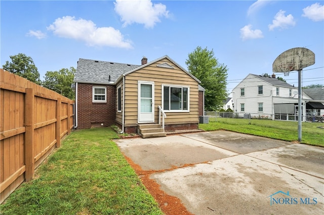 1447 Craigwood Rd, Toledo, OH 43612 - rear view of property featuring entry steps, a fenced backyard, a patio, a chimney, and roof with shingles