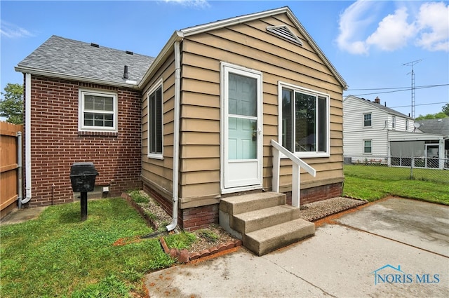 1447 Craigwood Rd, Toledo, OH 43612 - view of front of house with entry steps, roof with shingles, brick siding, and a patio