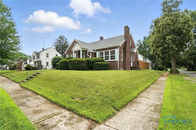1447 Craigwood Rd, Toledo, OH 43612 - bungalow-style home with brick siding, a chimney, and a front yard