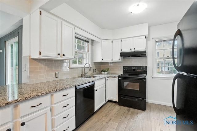 1447 Craigwood Rd, Toledo, OH 43612 - kitchen featuring black appliances, under cabinet range hood, light stone counters, and white cabinetry