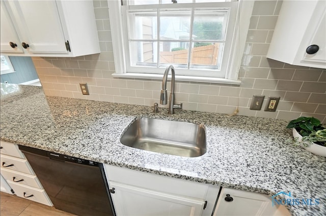 1447 Craigwood Rd, Toledo, OH 43612 - kitchen featuring dishwashing machine, white cabinetry, backsplash, and light stone counters
