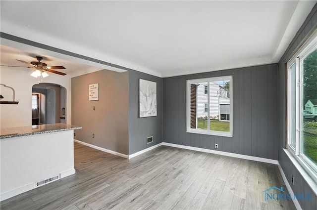 1447 Craigwood Rd, Toledo, OH 43612 - unfurnished living room with arched walkways, wood finished floors, healthy amount of natural light, and a ceiling fan