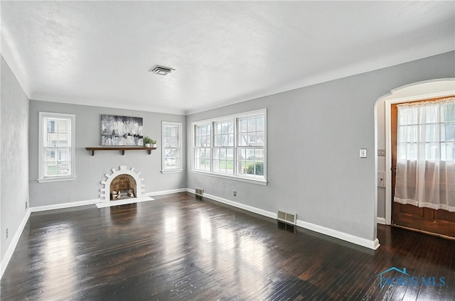 1447 Craigwood Rd, Toledo, OH 43612 - unfurnished living room with hardwood / wood-style flooring, plenty of natural light, a fireplace with flush hearth, and arched walkways