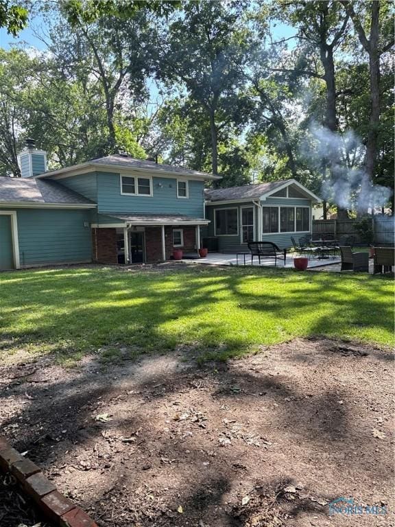 2920 Copland Blvd, Toledo, OH 43614 - back of property with a sunroom, a patio area, brick siding, and a chimney