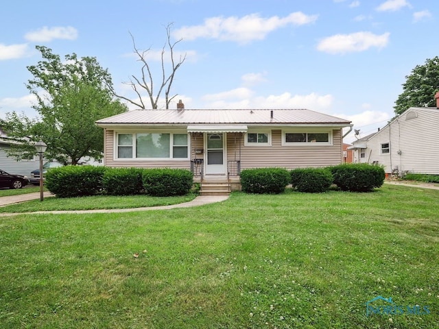 1242 Holgate Ave, Maumee, OH 43537 - view of front facade featuring a front yard, a chimney, and a metal roof