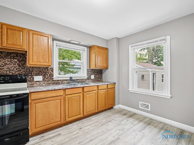 1242 Holgate Ave, Maumee, OH 43537 - kitchen with range with electric cooktop, light wood finished floors, healthy amount of natural light, and decorative backsplash