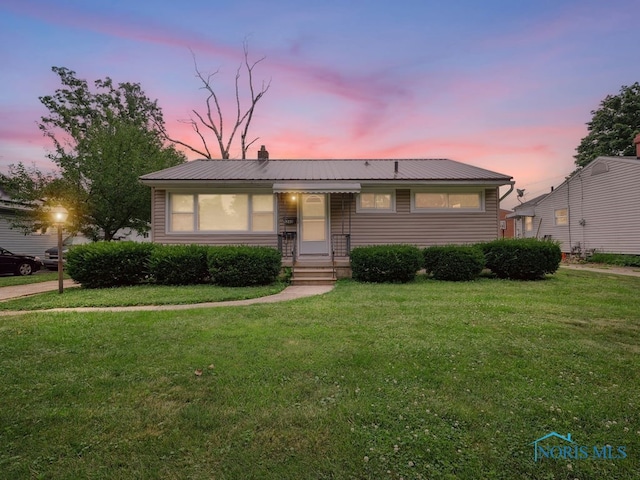 1242 Holgate Ave, Maumee, OH 43537 - view of front of property with a front yard, a chimney, and a metal roof