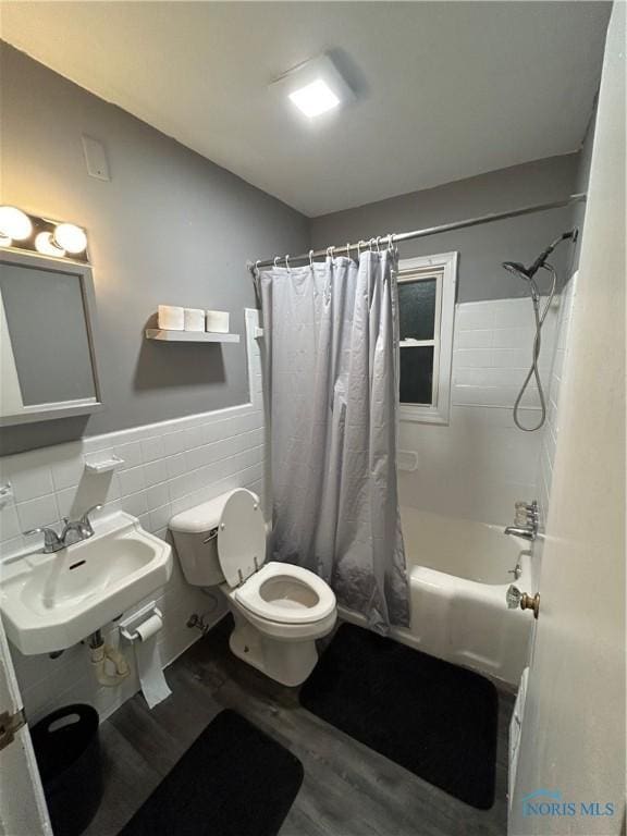 2127 Perth St, Toledo, OH 43607 - full bathroom with wood finished floors, shower / tub combo with curtain, a wainscoted wall, and tile walls