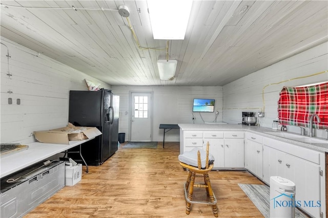 22804 State Route 2, Archbold, OH 43502 - kitchen with black fridge, light countertops, white cabinets, light wood-style floors, and a peninsula