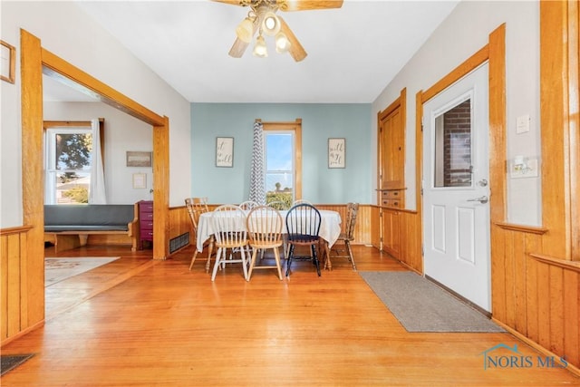 22804 State Route 2, Archbold, OH 43502 - dining space with light wood finished floors, ceiling fan, wood walls, and a wainscoted wall