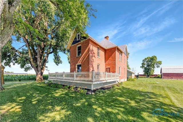 22804 State Route 2, Archbold, OH 43502 - rear view of house featuring a chimney, a lawn, brick siding, and a deck