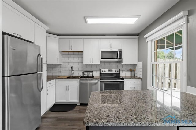 6627 Garden Rd Unit 6627, Maumee, OH 43537 - kitchen with stainless steel appliances, white cabinetry, dark stone countertops, and decorative backsplash