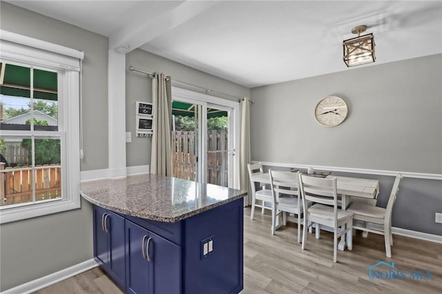 6627 Garden Rd Unit 6627, Maumee, OH 43537 - kitchen featuring blue cabinetry, a peninsula, light wood-type flooring, and stone countertops