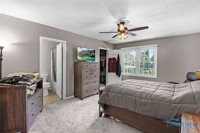 6627 Garden Rd Unit 6627, Maumee, OH 43537 - bedroom with light colored carpet, a walk in closet, connected bathroom, and ceiling fan