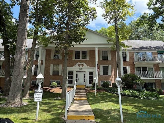 5679 Monroe St Unit 207, Sylvania, OH 43560 - greek revival house with a front lawn, brick siding, and french doors
