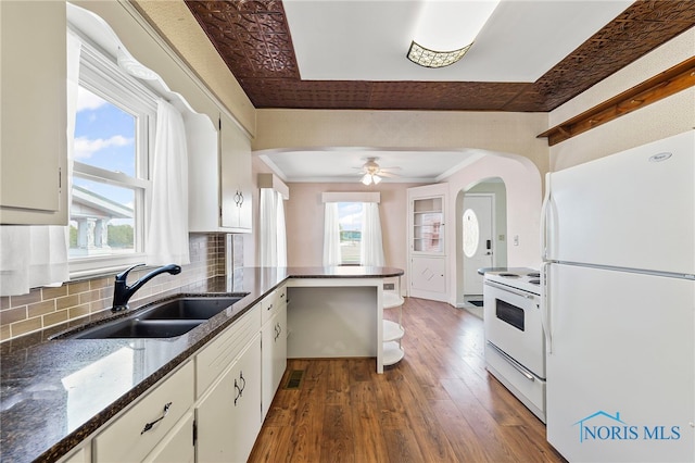 212 18th St, Findlay, OH 45840 - kitchen featuring white appliances, dark wood-type flooring, tasteful backsplash, a peninsula, and a tray ceiling