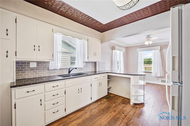 212 18th St, Findlay, OH 45840 - kitchen with white fridge with ice dispenser, open shelves, white cabinetry, tasteful backsplash, and wood finished floors