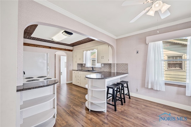 212 18th St, Findlay, OH 45840 - kitchen featuring open shelves, arched walkways, freestanding refrigerator, dark wood finished floors, and white cabinetry