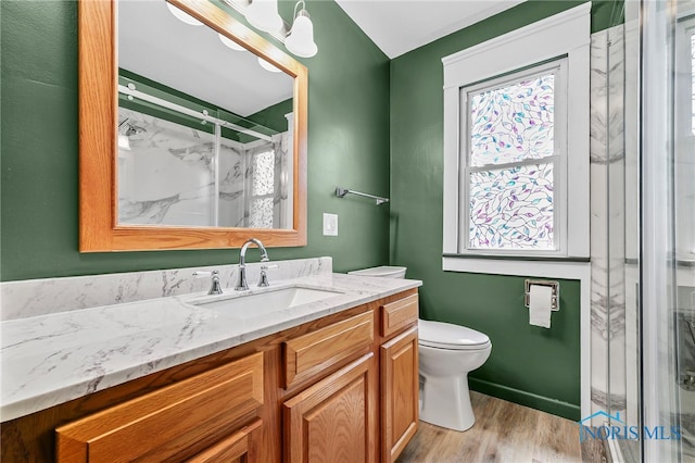 212 18th St, Findlay, OH 45840 - bathroom featuring a marble finish shower, vanity, wood finished floors, and healthy amount of natural light