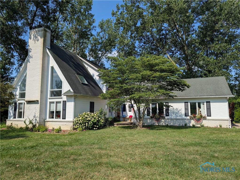 19579 Cross Creek Rd, Bowling Green, OH 43402 - view of front of house featuring a front yard, a chimney, and roof with shingles