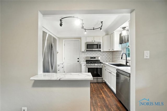 2838 Secor Rd, Toledo, OH 43606 - kitchen with appliances with stainless steel finishes, tasteful backsplash, white cabinets, light stone counters, and dark wood-style floors
