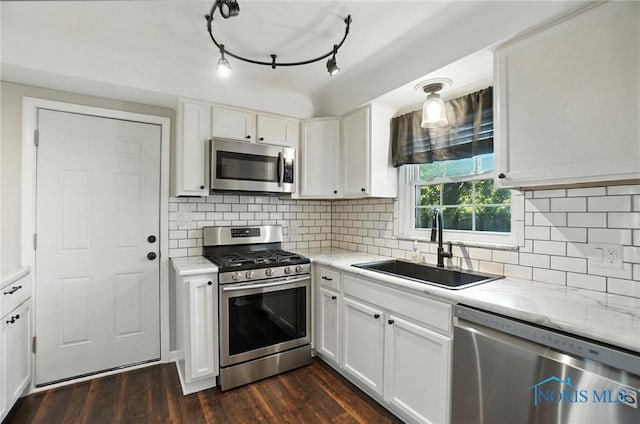 2838 Secor Rd, Toledo, OH 43606 - kitchen featuring appliances with stainless steel finishes, white cabinets, backsplash, and dark wood-style floors