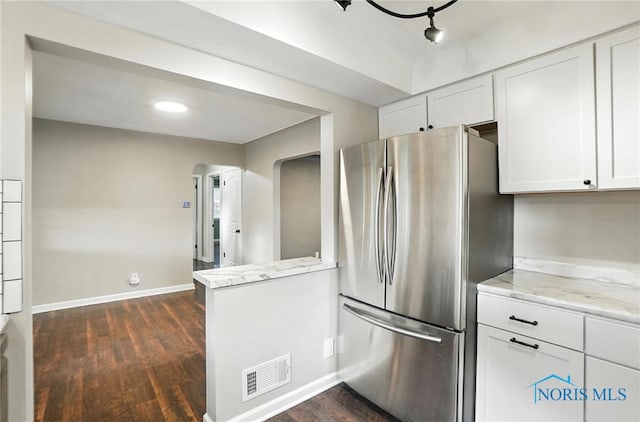 2838 Secor Rd, Toledo, OH 43606 - kitchen featuring freestanding refrigerator, arched walkways, white cabinets, dark wood finished floors, and light stone counters
