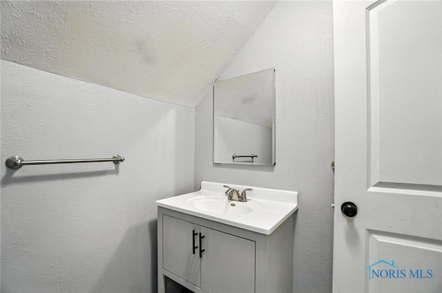 2838 Secor Rd, Toledo, OH 43606 - bathroom with vaulted ceiling, vanity, and a textured ceiling