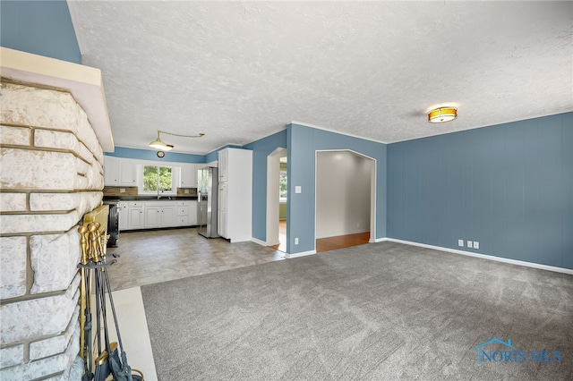 621 Bittersweet Dr, Findlay, OH 45840 - unfurnished living room featuring arched walkways, a textured ceiling, and carpet