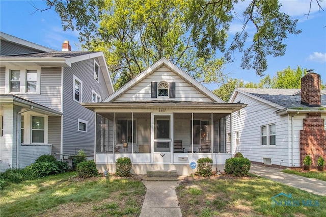 3867 Almeda Dr, Toledo, OH 43612 - view of front of property with a sunroom and a front lawn
