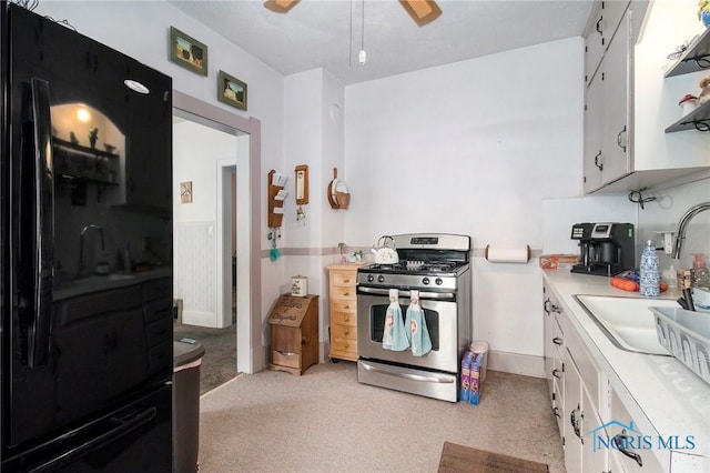 3867 Almeda Dr, Toledo, OH 43612 - kitchen with stainless steel gas range oven, white cabinets, light countertops, a ceiling fan, and freestanding refrigerator