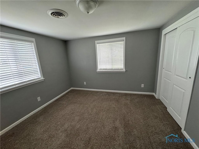 1712 Maumee Dr, Defiance, OH 43512 - unfurnished bedroom with a closet and dark carpet