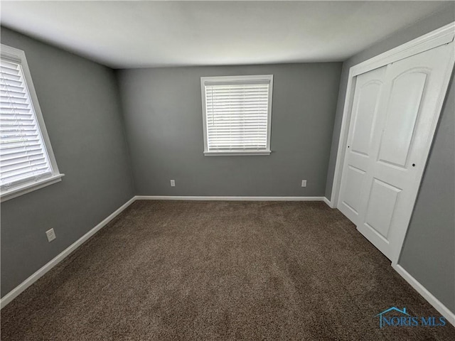 1712 Maumee Dr, Defiance, OH 43512 - unfurnished bedroom with dark colored carpet, multiple windows, and a closet