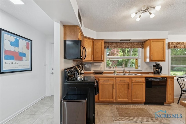 3468 Hughes Blvd, Toledo, OH 43606 - kitchen with black appliances, light tile patterned flooring, plenty of natural light, a textured ceiling, and brown cabinetry