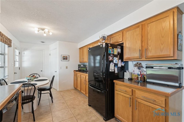 3468 Hughes Blvd, Toledo, OH 43606 - kitchen featuring black appliances, a textured ceiling, light tile patterned floors, dark countertops, and brown cabinets