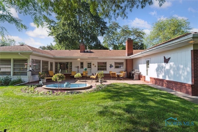 3468 Hughes Blvd, Toledo, OH 43606 - rear view of property featuring a chimney, a lawn, brick siding, and a patio area