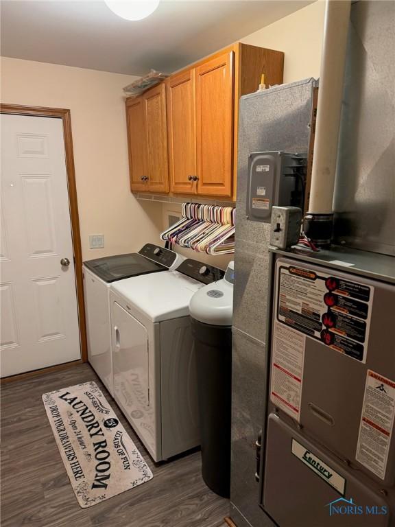 110 Town Line Rd, Bryan, OH 43506 - washroom featuring cabinet space, washer and dryer, dark wood-style flooring, and heating unit