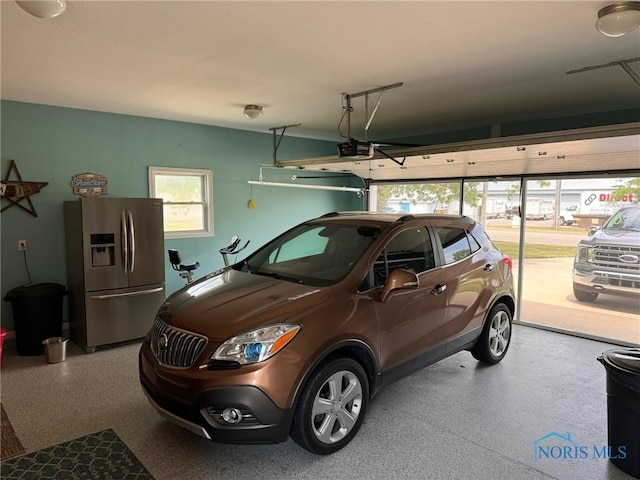 110 Town Line Rd, Bryan, OH 43506 - garage with stainless steel fridge with ice dispenser and a garage door opener