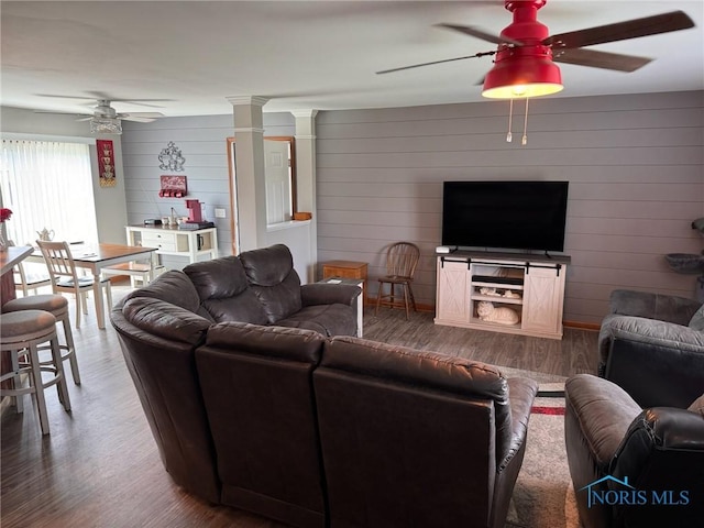 110 Town Line Rd, Bryan, OH 43506 - living room with ceiling fan, wood finished floors, ornate columns, and wooden walls