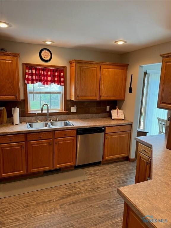 110 Town Line Rd, Bryan, OH 43506 - kitchen with dishwasher, light wood finished floors, decorative backsplash, light countertops, and brown cabinetry