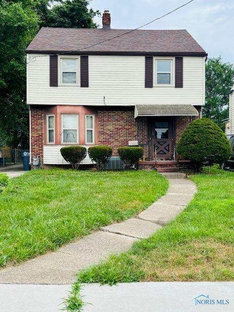 4136 Berwick Ave, Toledo, OH 43612 - colonial home with brick siding, a front yard, and a chimney