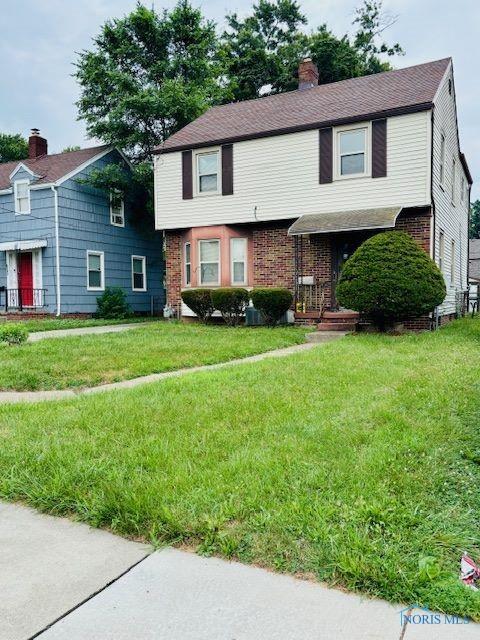 4136 Berwick Ave, Toledo, OH 43612 - colonial-style house with a chimney, brick siding, and a front yard