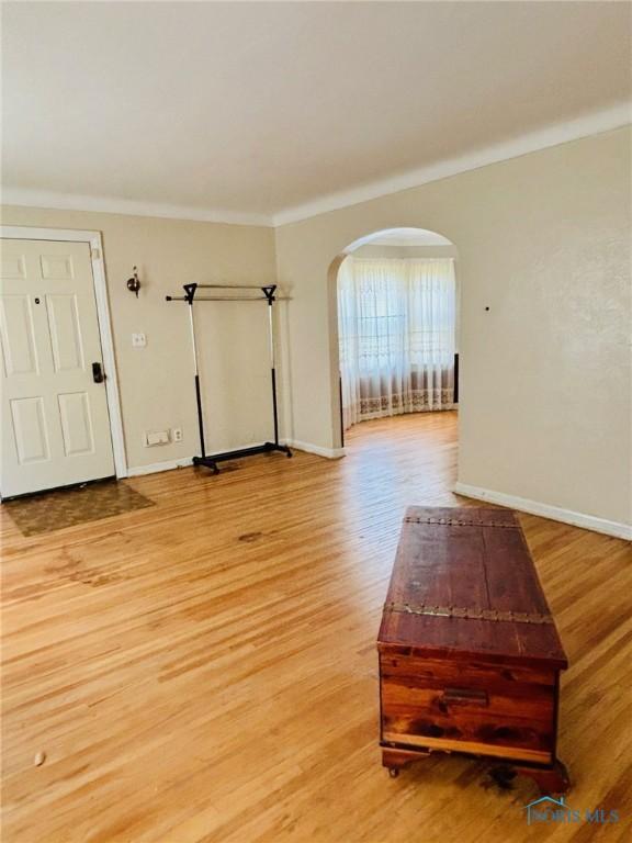 4136 Berwick Ave, Toledo, OH 43612 - empty room featuring arched walkways, light wood-type flooring, and crown molding