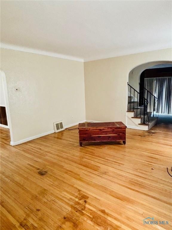 4136 Berwick Ave, Toledo, OH 43612 - unfurnished room featuring arched walkways, wood finished floors, stairway, and crown molding