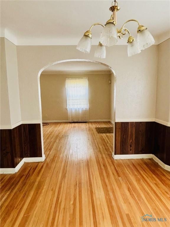 4136 Berwick Ave, Toledo, OH 43612 - unfurnished room featuring arched walkways, wood finished floors, and a chandelier